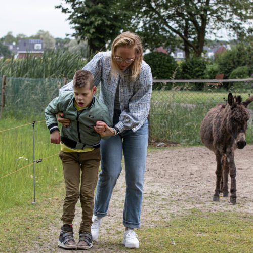 Begeleider helpt Lars met lopen